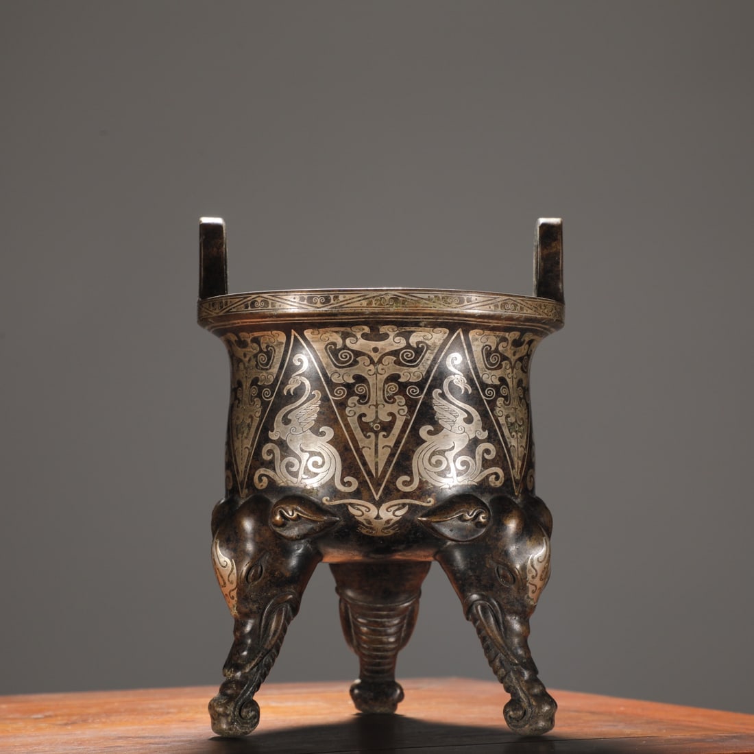 A Ming Dynasty finely cast bronze inlaid silver thread kui phoenix pattern elephant foot sky-eared: Ming dynasty finely cast bronze body with silver thread kui phoenix patterns, elephant-foot sky-eared burner Size: H:17cm Calibre: 12cm W: 2.1 kg (The Dimensions Of All Batches Are Manually Measured.I