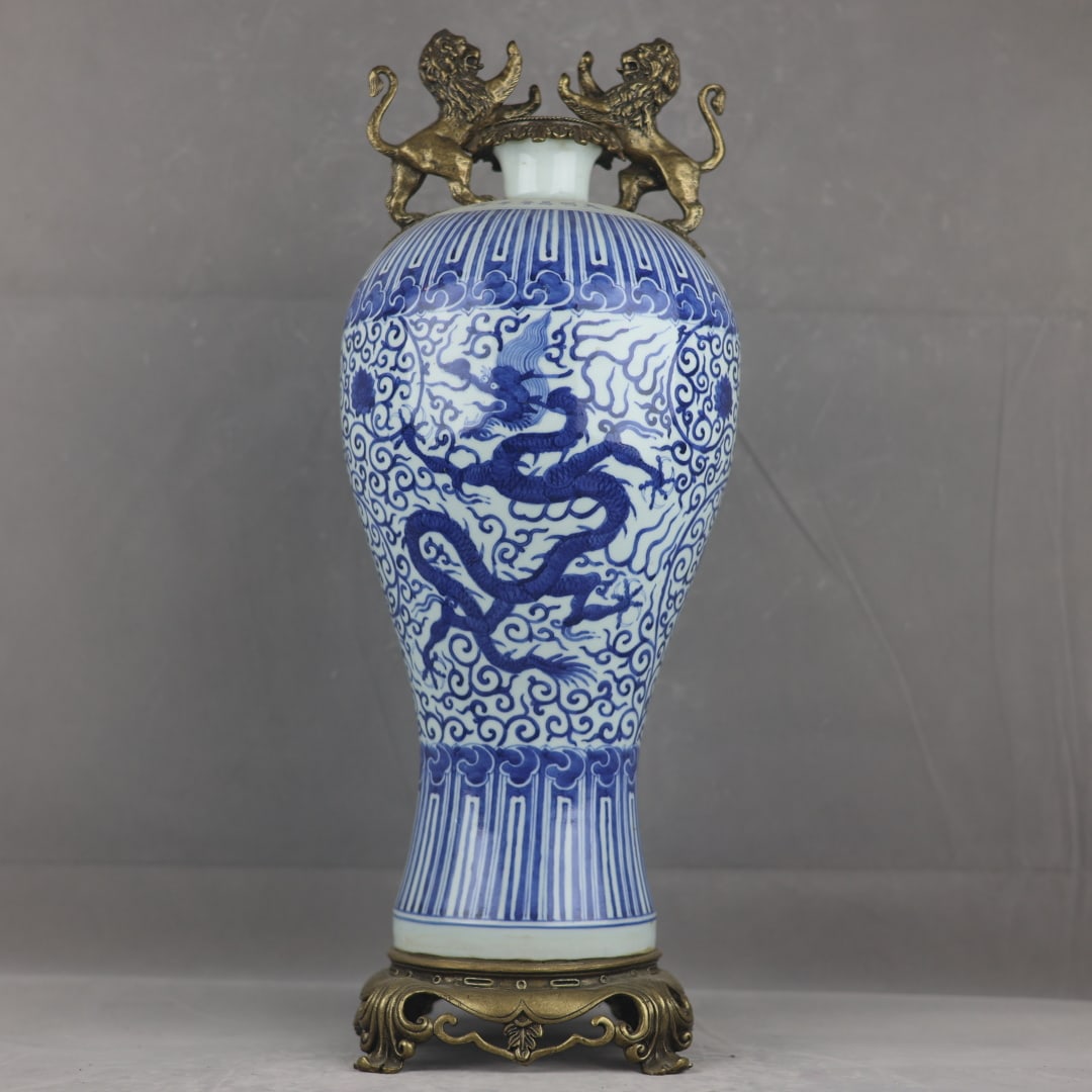 A beautiful blue-and-white entwined cloud and dragon pattern, gilded copper double lion-handle plum: A beautiful blue-and-white plum vase with entwined branches and cloud dragon patterns, inlaid with copper and gilt double lion-handle plum ears Size:H:56.5cm Calibre:9cm D:21cm Bottom:18.5cm (The Dime