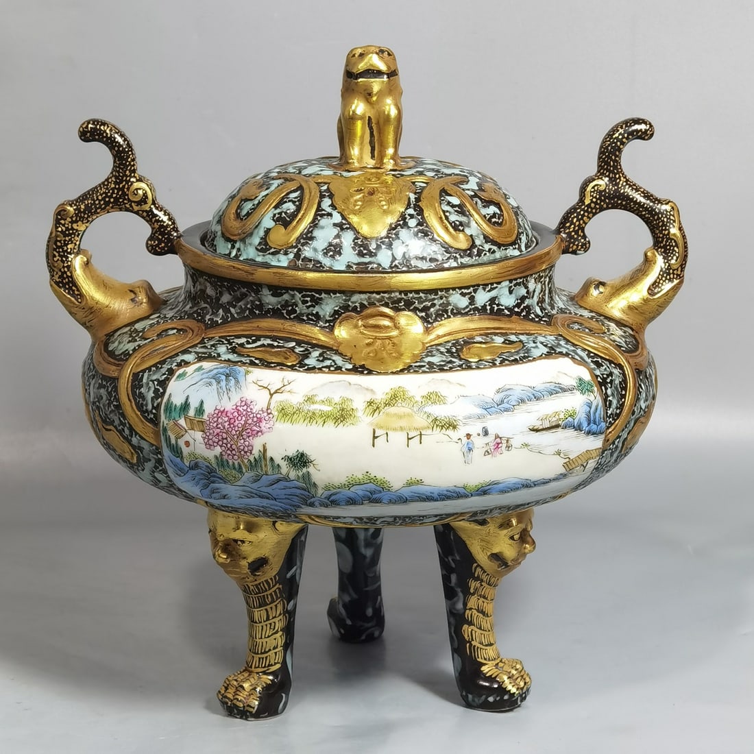 An antique bronze incense burner with a three-legged lid and a window painting landscape carved with: An antique bronze incense burner with a three-legged lid and a window painting landscape with a figure, made during the Qianlong period of the Qing Dynasty Size: H: 19.8 cm x Belly diameter: 17 cm (Th