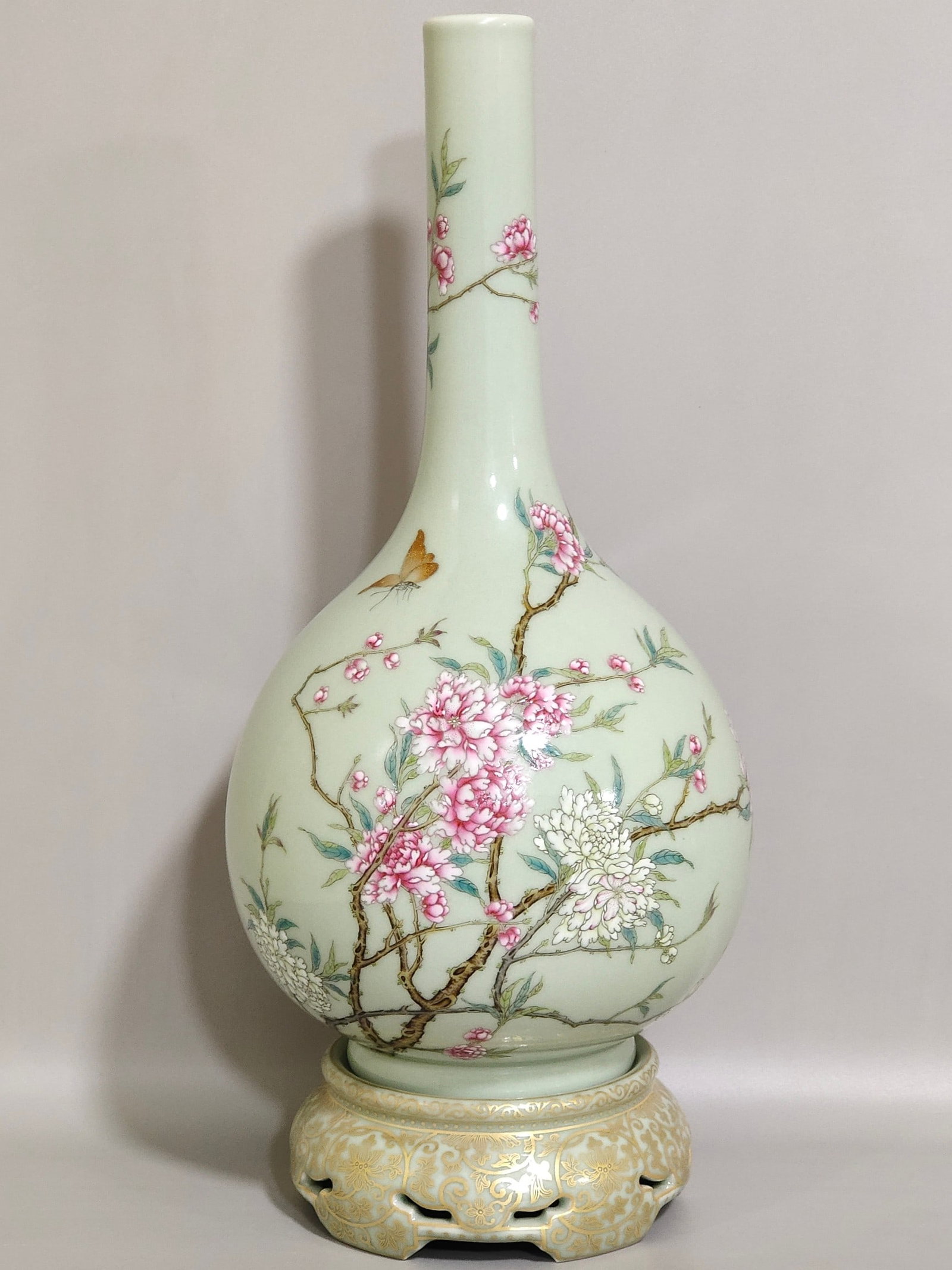 A Qing Dynasty Qianlong period long-necked vase with bean green glaze and gilded butterfly love: A long-necked vase with bean blue glaze painted with gold, butterfly and flower love, made during the Qianlong period of the Qing Dynasty Size:32x13.5 cm (The Dimensions Of All Batches Are Manually Me