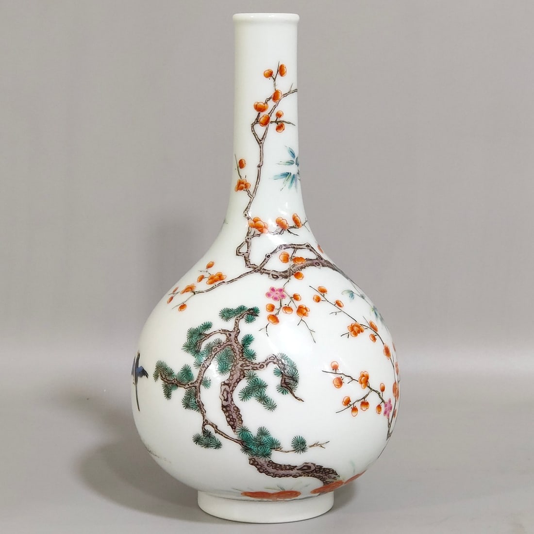 A Qing Dynasty Yongzheng period long-necked vase featuring the Three Friends Pine, Bamboo, and Plum: A long-necked vase from the Yongzheng period of the Qing Dynasty with the Three Friends of Pine, Bamboo, and Plum, made during the Yongzheng era Size:15.9x8.5 cm (The Dimensions Of All Batches Are Man