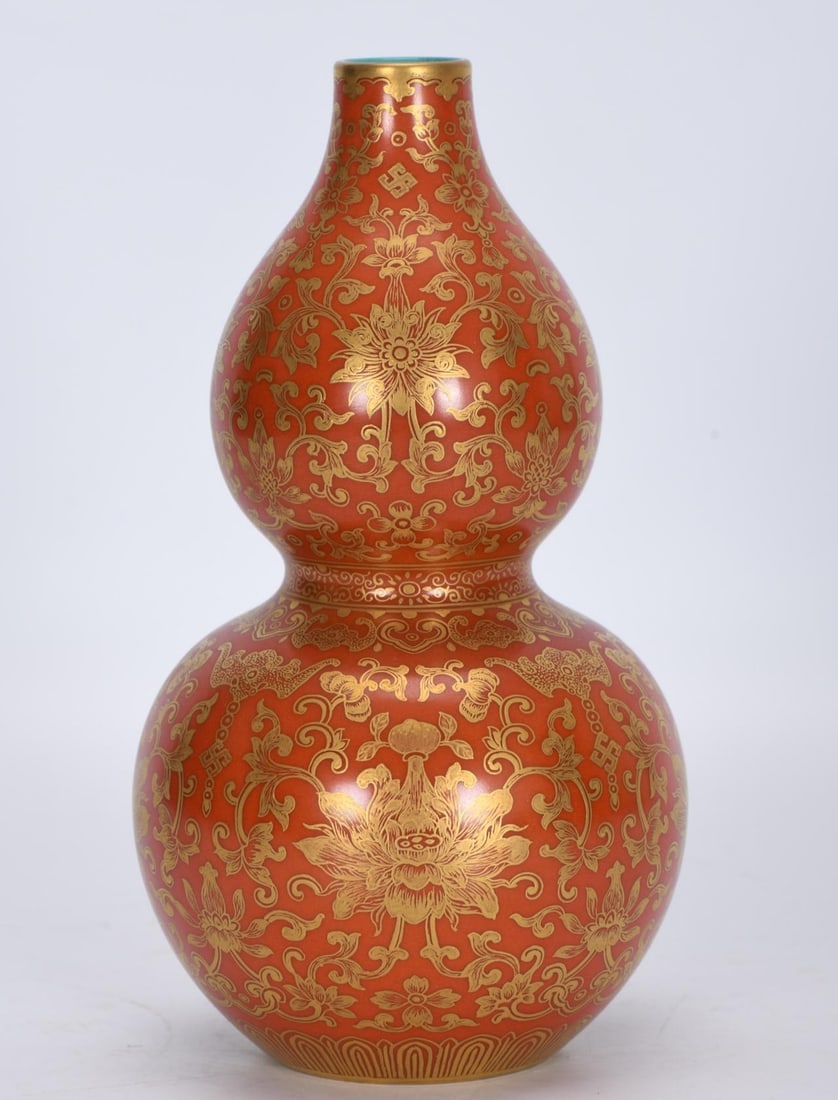 A Qing Dynasty Qianlong period enamel coral-red gold-stacked lotus gourd vase made during the: A gourd vase made during the Qianlong period of the Qing Dynasty, with enamel, colored coral, red piles, and gold entwined lotus branches Size: H: 20.5 cm xCalibre: 2.6 cm x Belly diameter: 11.3 cm xB