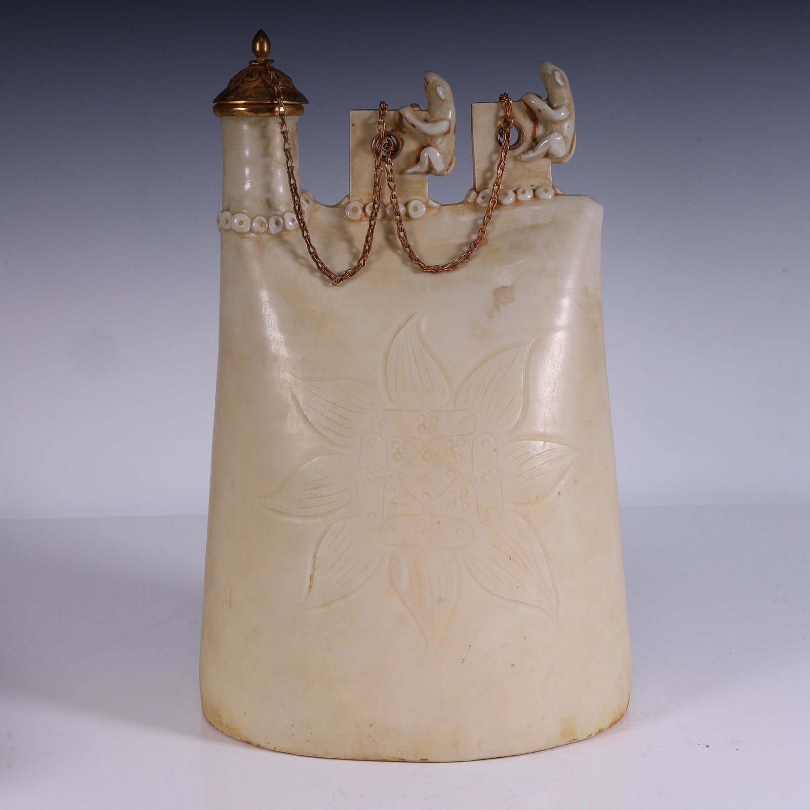 A beautifully crafted white-glazed carved leather pouch teapot