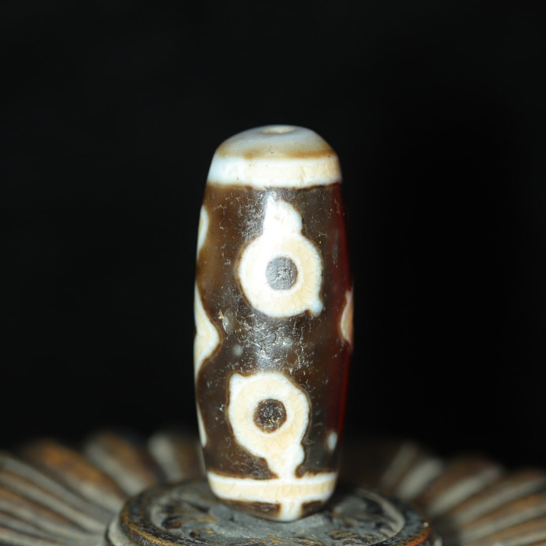 A beautifully crafted oil-soaked three-eyed Dzi bead: Exquisite oil-soaked three-eyed Dzi beads Size:39x15mm W: 0.016 kg (The Dimensions Of All Batches Are Manually Measured.If You Need More Detailed Information, Please Contact Our Customer Service Befor