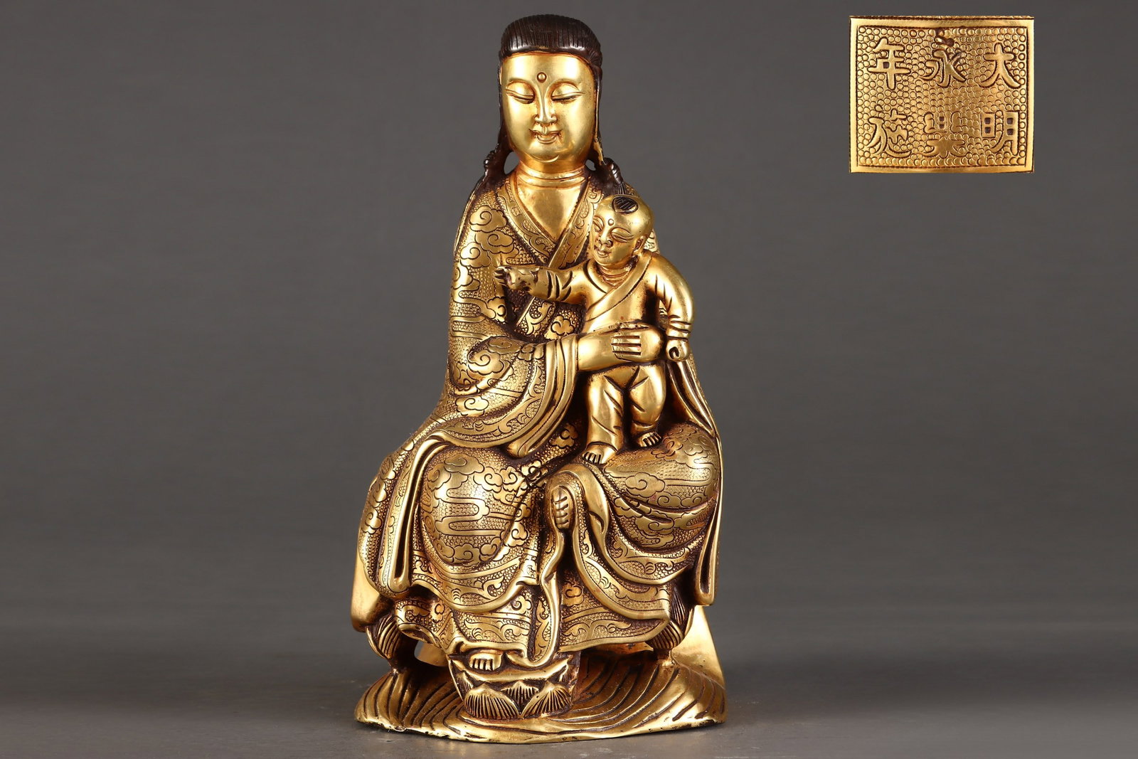 A Ming Dynasty finely cast bronze gilt seated Guanyin statue depicting 'Child-Bearing Guanyin.': A finely cast bronze-plated seated Guanyin statue depicting childbearing from the Ming dynasty Size:H:23.5cm W:12.2cm W:3.55kg (The Dimensions Of All Batches Are Manually Measured.If You Need More Det