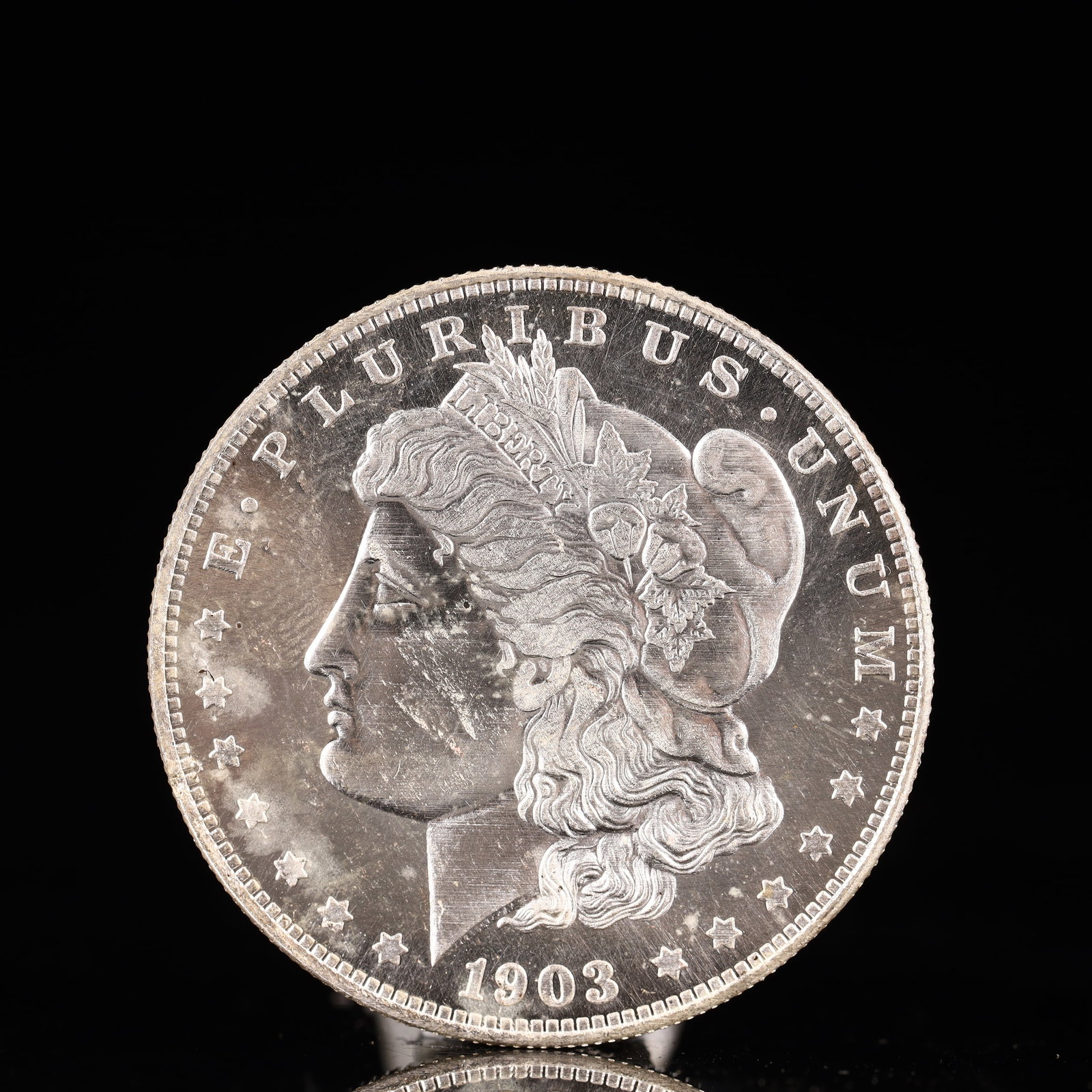 USA Morgan Dollar 1903 Coin: Obv: profile bust with date below and E PLURIBUS UNUM legend and stars around. Rev: eagle with In God we trust above within wreath with UNITED STATES OF AMERICA ONE DOLLAR legend. IN GOD WE TRUST / LI