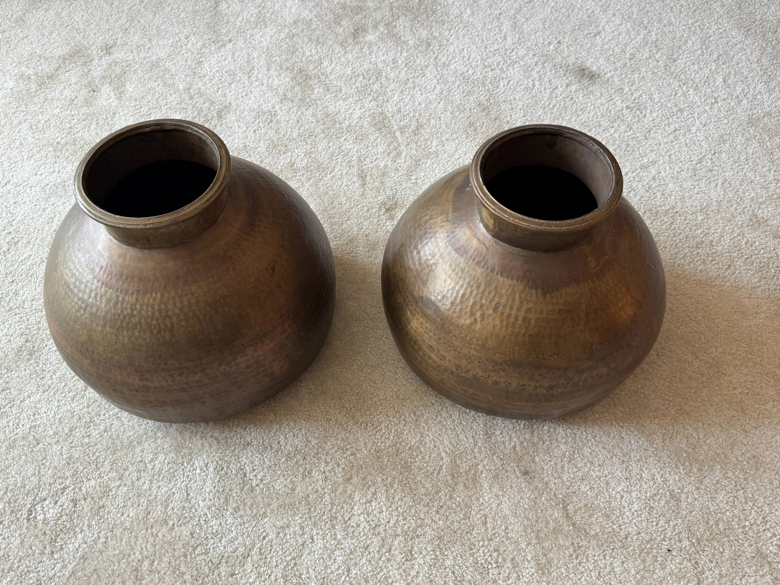 Pair of SAS Living Indian Brass Lota Water: A fine pair of antique Indian brass water vessels (Lota/Matka). Each vessel features a beautiful, bulbous form hand-forged with a traditional textured hammer finish throughout the body. The pots