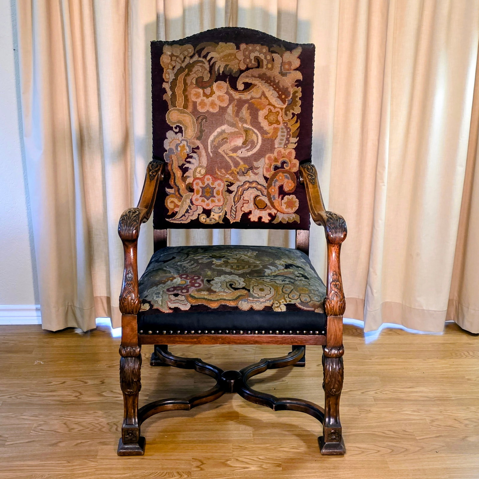 Walnut Throne with Needlepoint Upholstery and Carved Floral Detail: Very bold and stately this English throne or hall chair makes a dramatic statement. Featuring a crane motif in the needlepoint. there is a repair made on the front of the seat to the needlepoint.
