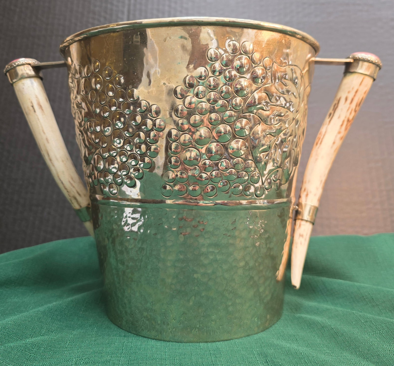 MCM Italian Brass Ice Bucket with Horn Handles by Neroni & Zonca: Crafted from heavy, polished golden brass featuring a distinctive hand-hammered Dimple/Martellato texture on the lower half that creates a beautiful play of light.Embossed Relief Artwork: The upper