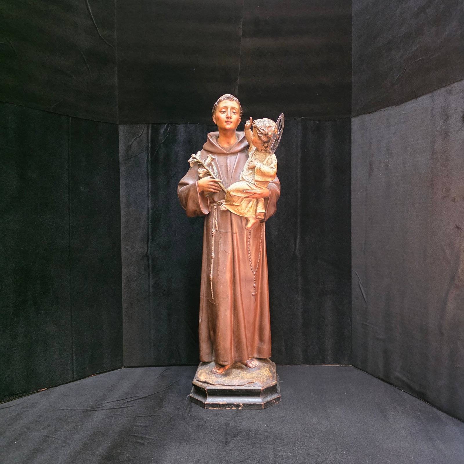 Saint Anthony of Padua holding the Christ Child by Arte Christiano-Olot, Spain: This is a tall 25" wonderful polychrome wood paste statue with glass eyes and hand painted details. There has been a repair to the baby's head.