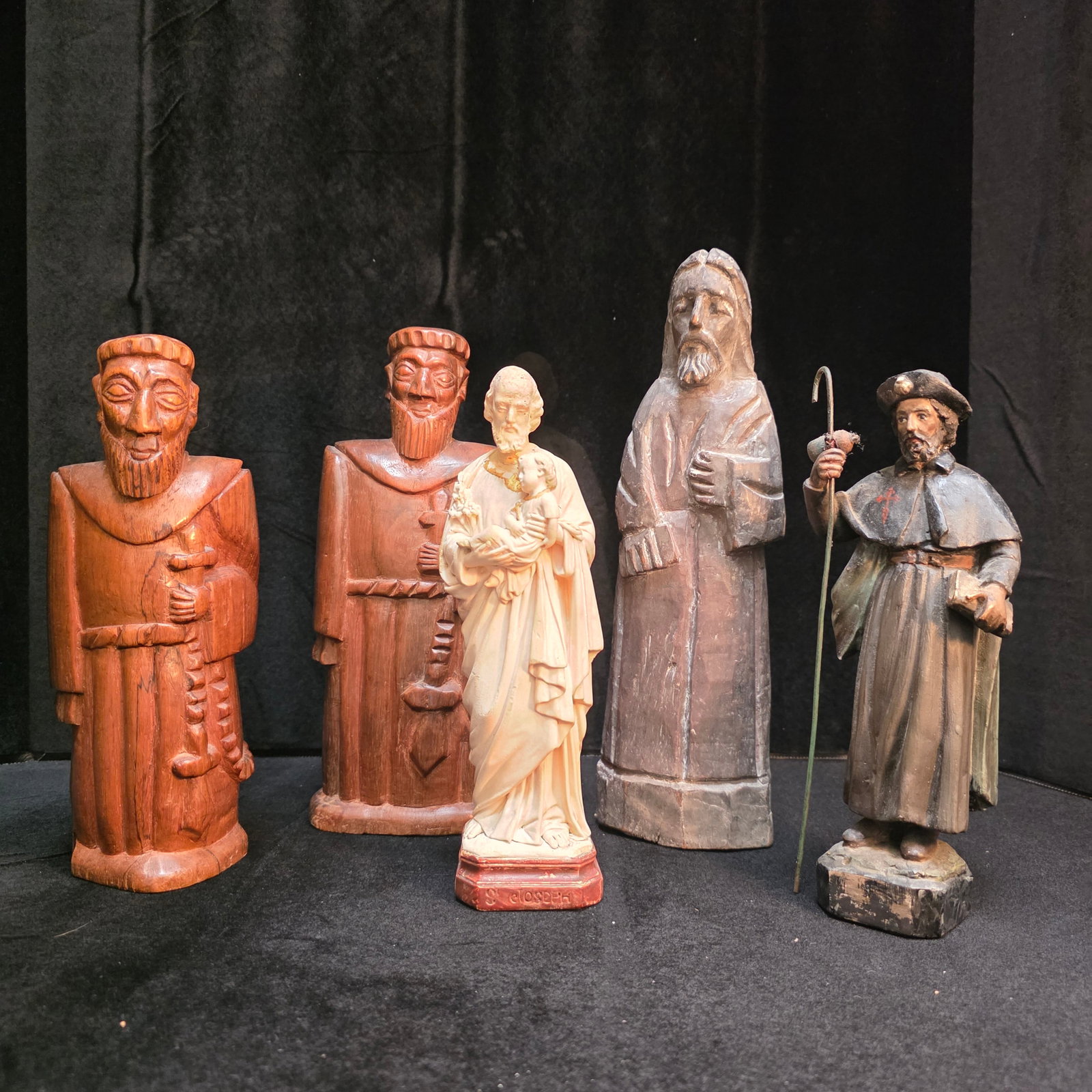 Lot of Five Wooden Monks and Saint Statues: 2 wood carved monks- one measures 8x4x4, and the other measures 10x3x4-Believed to be Pau Brasil Wood. One White Pieraccini-Signed Joesph 8x3wx2. One lkart Jesus Santos Populares 10x4x2 hand carved