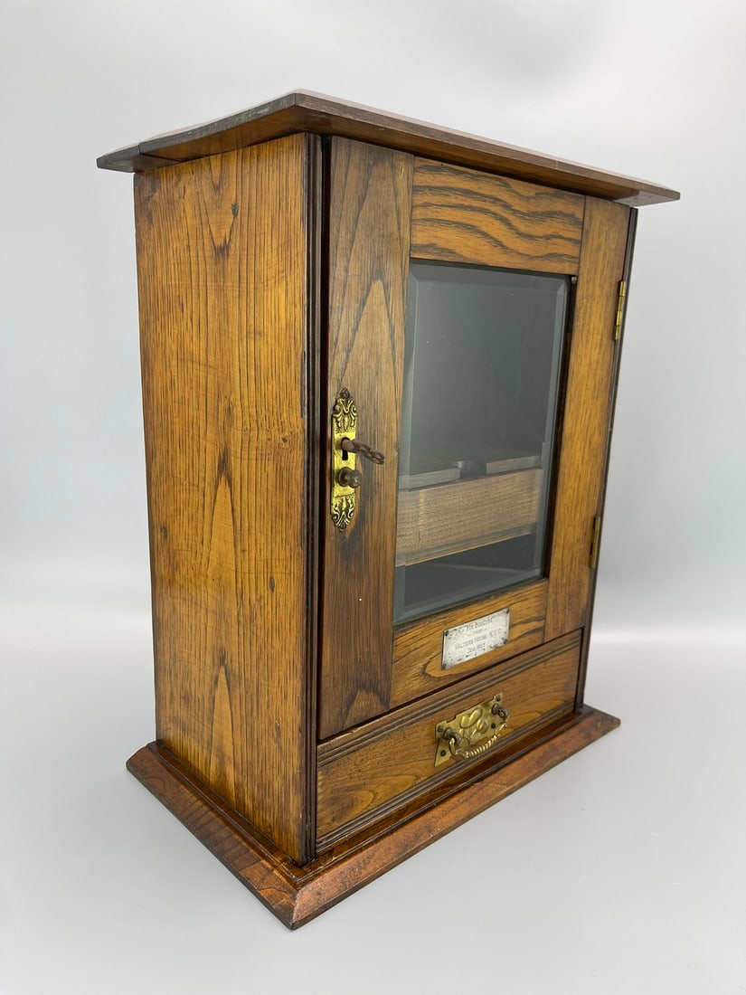A SOLID OAK PIPE CABINET, 1925 - 2