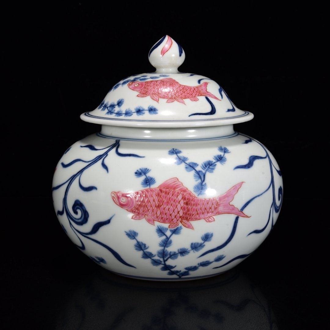 A BLUE-AND-WHITE RUBY RED-GLAZED 'FISH AND WEEDS' COVERED JAR: A BLUE-AND-WHITE RUBY RED-GLAZED 'FISH AND WEEDS' COVERED JAR Dimensions: Length: 1800 cm (708.7 in.), Width: 1700 cm (669.3 in.). All measurements are approximate.