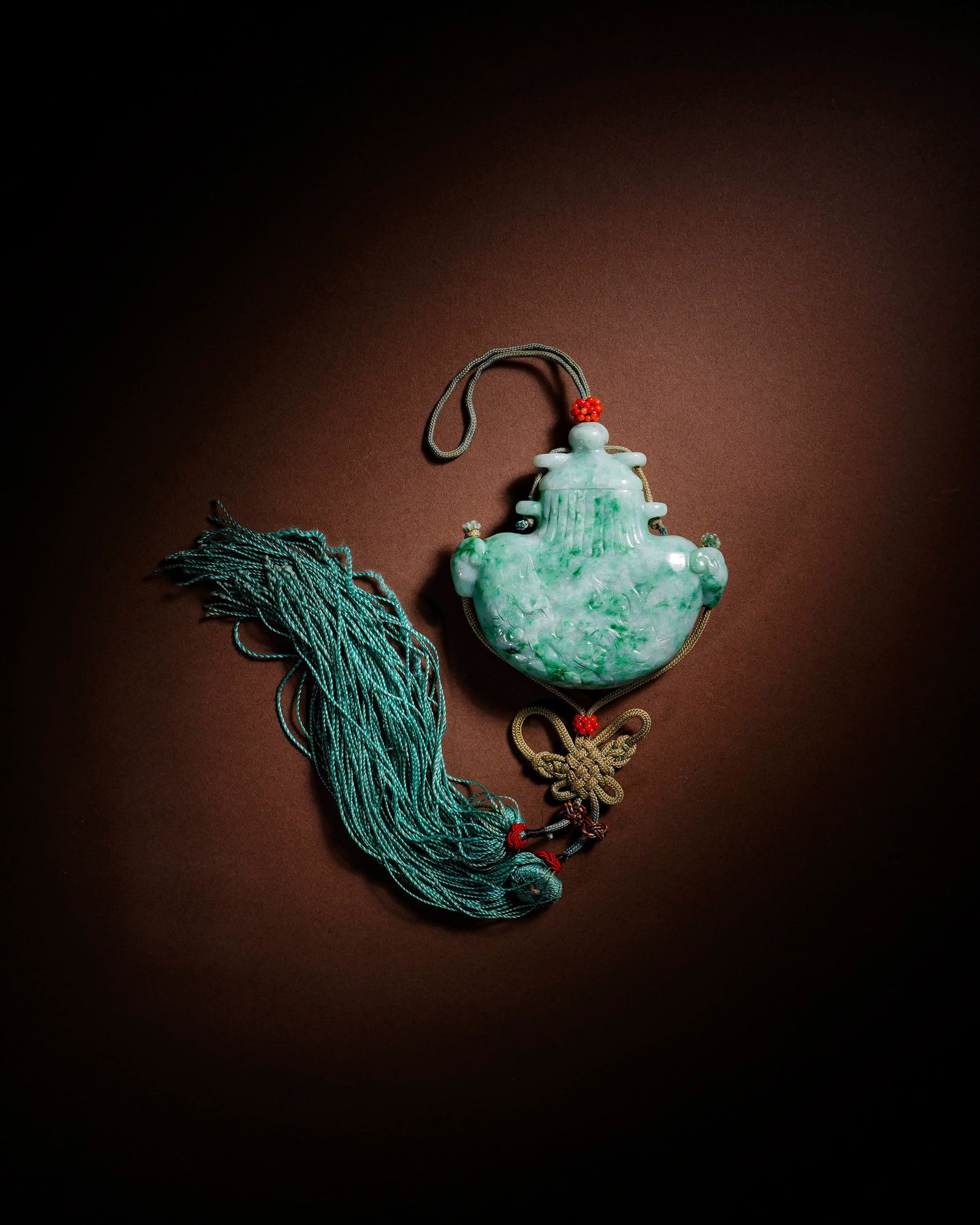 A JADEITE SACHET PENDANT: A JADEITE SACHET PENDANT Length: 7 cm (2.8 in.), Height: 6.7 cm (2.6 in.). All measurements are approximate.