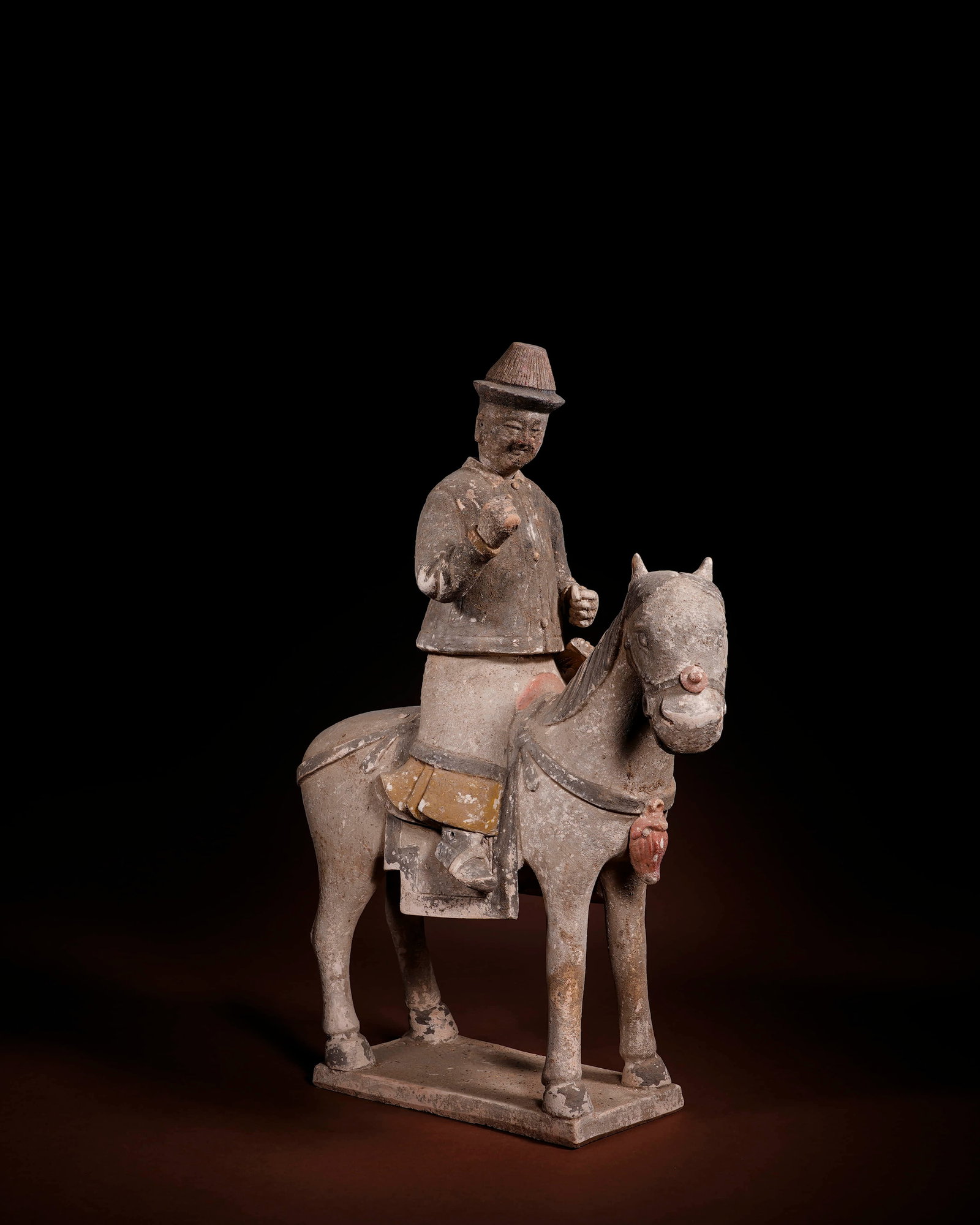 A PAINTED POTTERY 'OFFICIAL IN BLACK ROBE WITH DETACHABLE HEAD' HORSE AND ATTENDANT: A PAINTED POTTERY 'OFFICIAL IN BLACK ROBE WITH DETACHABLE HEAD' HORSE AND ATTENDANT Length: 39 cm (15.4 in.), Height: 28 cm (11.0 in.). All measurements are approximate.