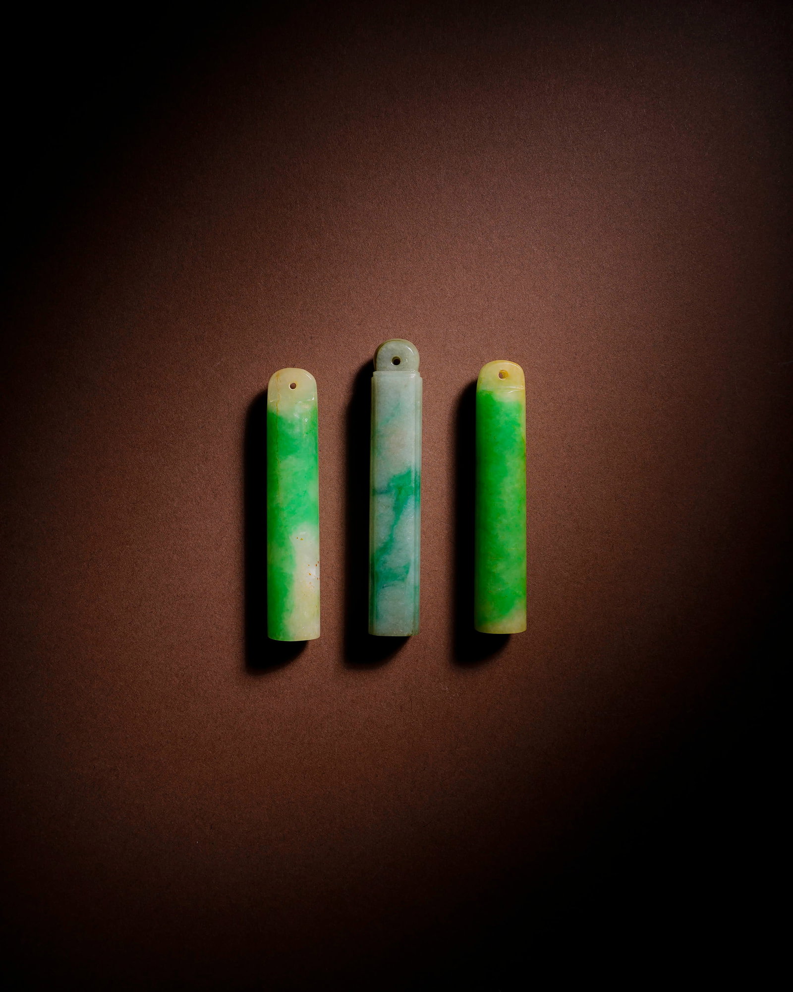 A JADEITE FEATHER TUBE: A JADEITE FEATHER TUBE Item 1: Length: 1.3 cm (0.5 in.), Height: 7 cm (2.8 in.); Item 2: Length: 1.5 cm (0.6 in.), Height: 7 cm (2.8 in.); Item 3: Length: 1.3 cm (0.5 in.), Height: 7.8 cm (3.1 in.). A
