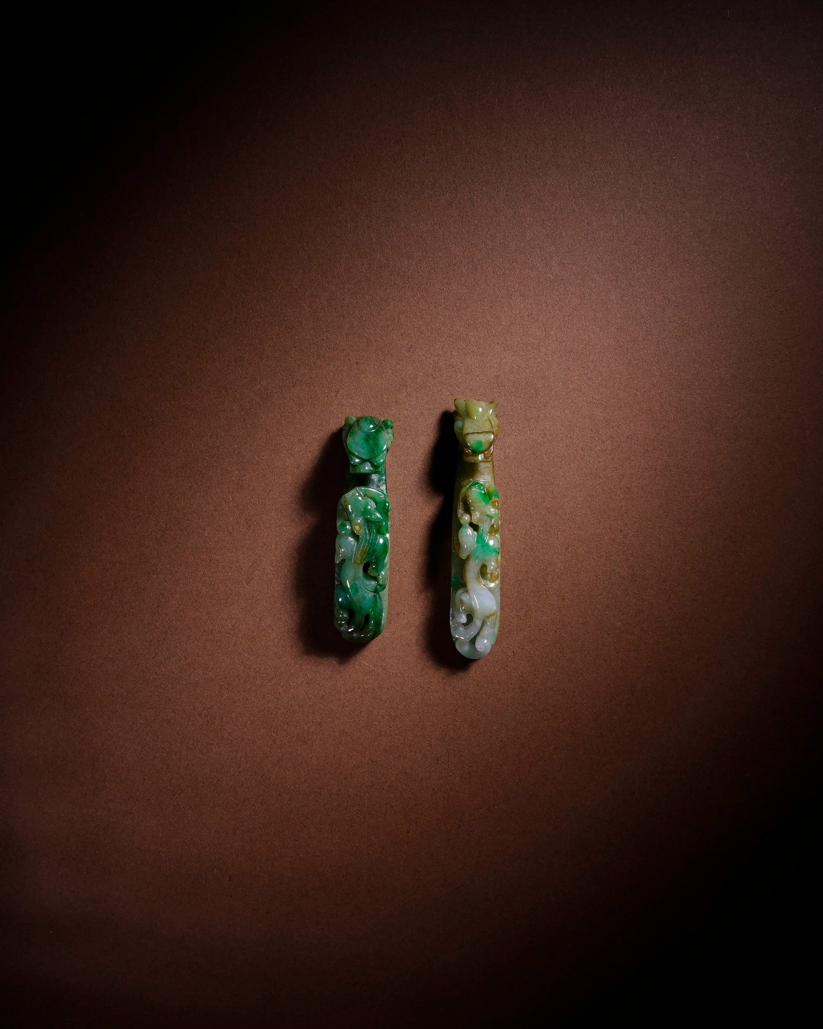 A PAIR OF JADEITE DRAGON-SHAPED HOOKS: A PAIR OF JADEITE DRAGON-SHAPED HOOKS Item 1: Length: 1.2 cm (0.5 in.), Height: 6.3 cm (2.5 in.); Item 2: Length: 1.3 cm (0.5 in.), Height: 5.5 cm (2.2 in.). All measurements are approximate.