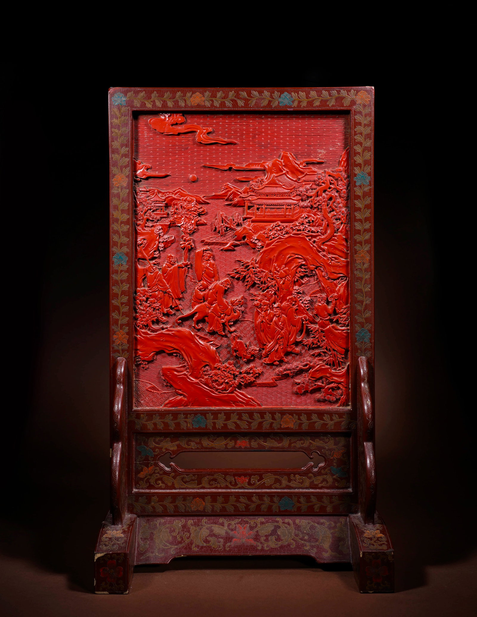 A CARVED RED LACQUER 'SCHOLARS GATHERING' TABLE SCREEN: A CARVED RED LACQUER 'SCHOLARS GATHERING' TABLE SCREEN Length: 33.1 cm (13.0 in.), Height: 57.7 cm (22.7 in.). All measurements are approximate.