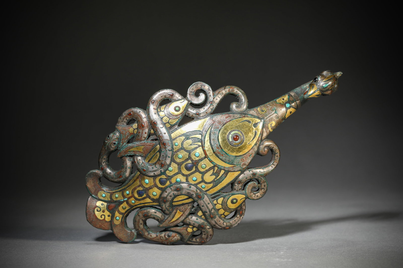 A COPPER-INLAID GOLD AND SILVER 'DRAGON AND PHOENIX' BELT HOOK: A COPPER-INLAID GOLD AND SILVER 'DRAGON AND PHOENIX' BELT HOOK Weight: 569 g, Length: 19.8 cm (7.8 in.), Width: 10.6 cm (4.2 in.), Height: 3.9 cm (1.5 in.). All measurements are approximate.