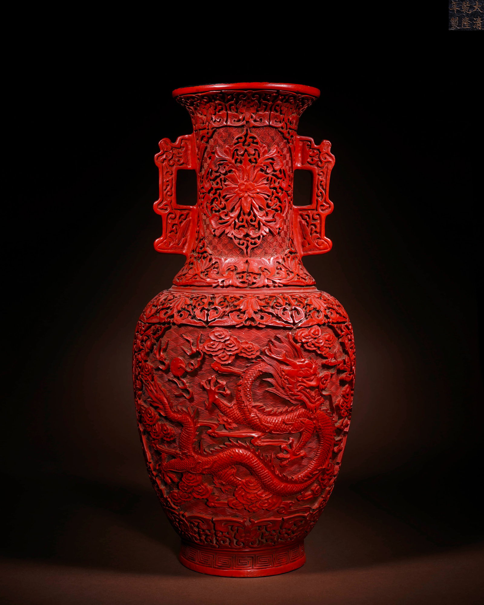 A CARVED RED LACQUER 'FLOWERS AND DRAGON' TWO-HANDLED VASE: A CARVED RED LACQUER 'FLOWERS AND DRAGON' TWO-HANDLED VASE Length: 19.5 cm (7.7 in.), Height: 45.3 cm (17.8 in.). All measurements are approximate.