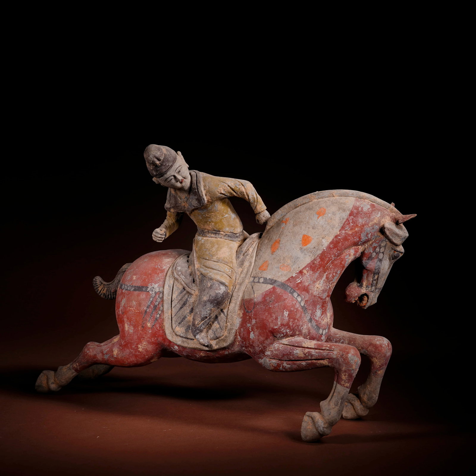 A PAINTED POTTERY 'POLO-PLAYER' FIGURINE: A PAINTED POTTERY 'POLO-PLAYER' FIGURINE Length: 36.5 cm (14.4 in.), Height: 26.5 cm (10.4 in.). All measurements are approximate.