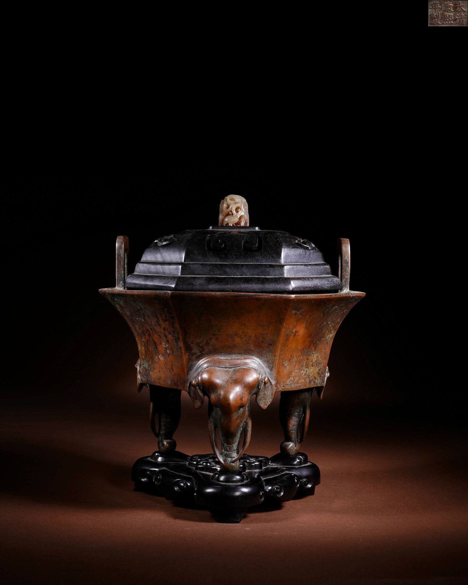A BRONZE 'ELEPHANT BEARING A VASE' HEXAGONAL INCENSE BURNER: A BRONZE 'ELEPHANT BEARING A VASE' HEXAGONAL INCENSE BURNER Length: 22 cm (8.7 in.), Height: 25 cm (9.8 in.). All measurements are approximate.