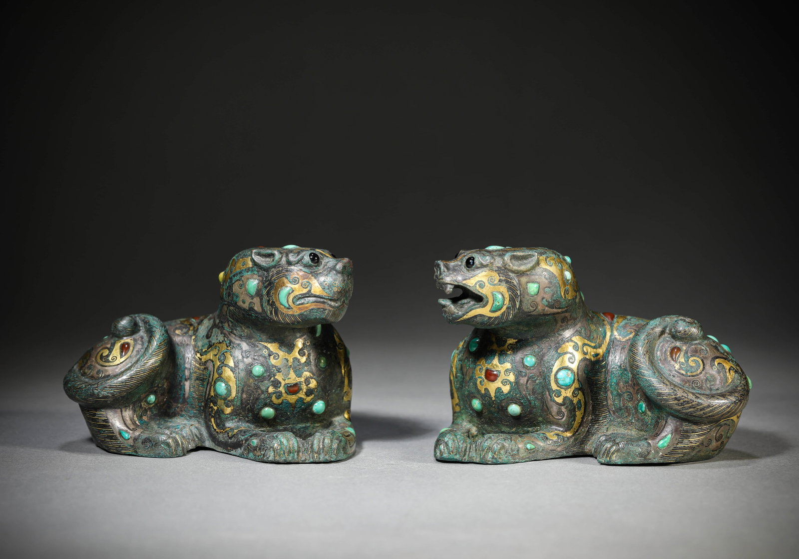 A PAIR OF COPPER-INLAID GOLD AND SILVER 'AUSPICIOUS BEASTS': A PAIR OF COPPER-INLAID GOLD AND SILVER 'AUSPICIOUS BEASTS' Weight: 2425 g, Length: 10.2 cm (4.0 in.), Width: 4.7 cm (1.9 in.), Height: 6.7 cm (2.6 in.). All measurements are approximate.