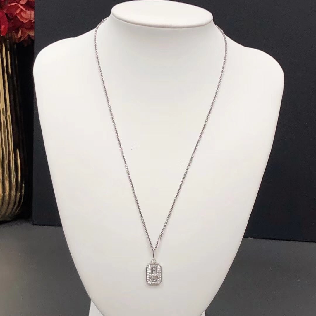 Harry Winston HW Logo Diamond Pendant 18K White Gold Size L: Product DetailsMaterial: 18K White Gold.Design: Features an engraved "HW" logo at the center, surrounded by a border of pave-set round brilliant diamonds.This piece is part of the Charms by Harry Wins