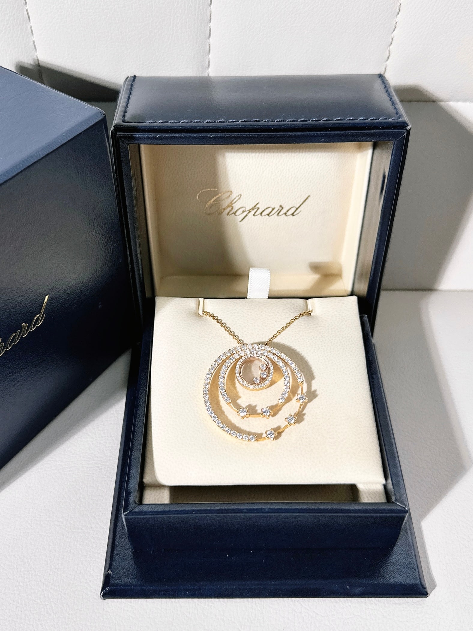 Chopard's Happy Diamonds 18K Gold Full Diamond Pendant: Chopard Happy Diamonds collection, specifically a design featuring concentric hoops and stars.Key Features of the NecklaceCollection: Happy Diamonds.Design: The pendant consists of multiple concentric