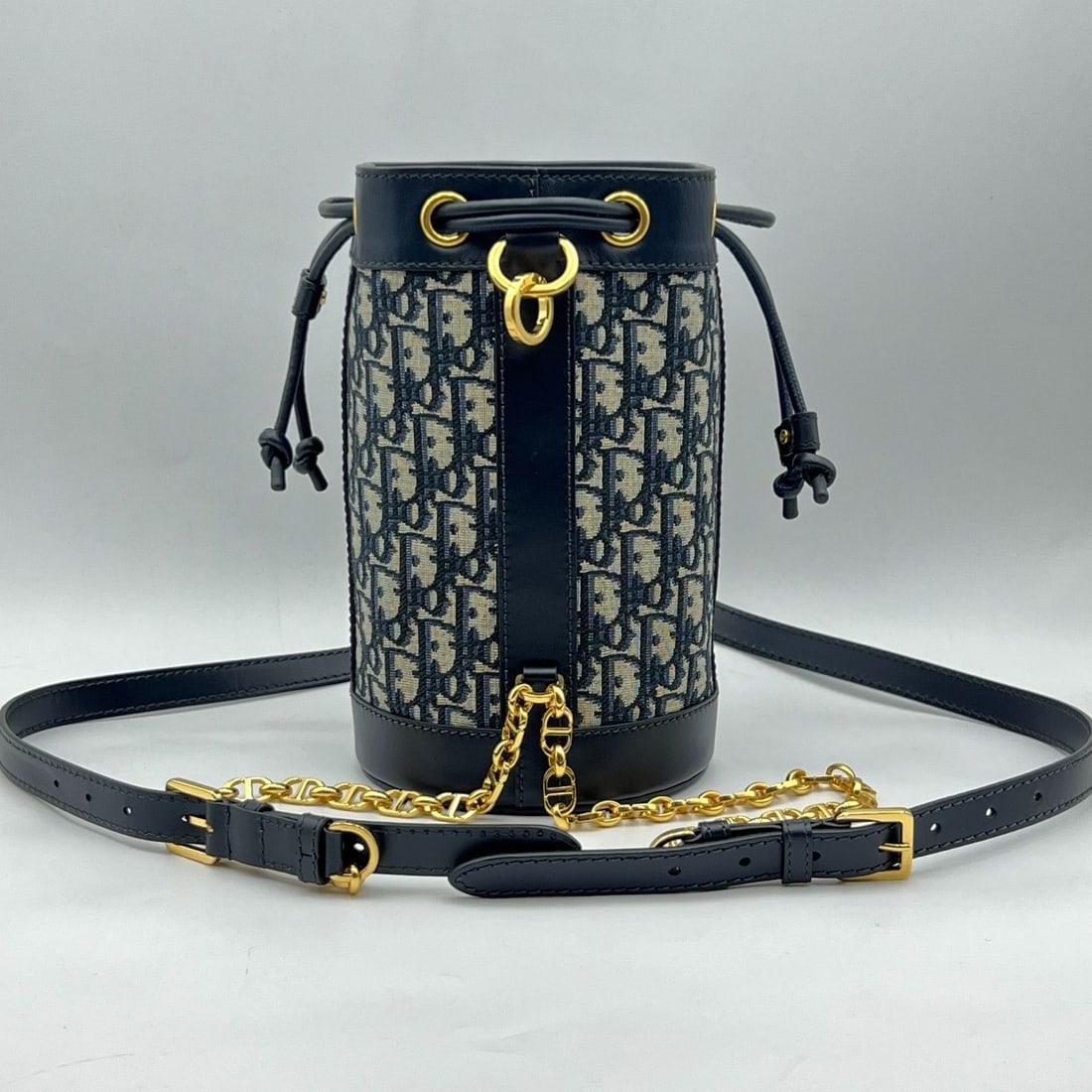 Christian Dior Oblique Canvas Leather Small Drawstring Backpack Bucket Bag Chip: Normal signs of wear, slight scratches on hardware, minor creases on leather surface, clean inside and out.