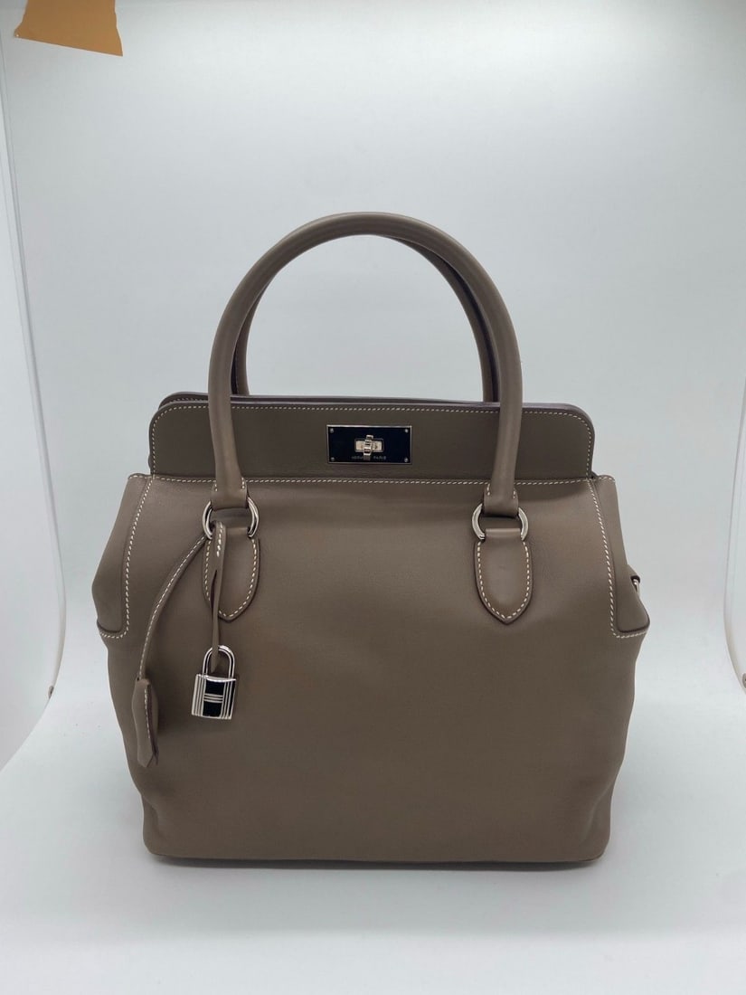 100% Auth Hermes Toolbox 26 Bag Leather Etoupe Stmap R PHW Origin France: Normal signs of use, wear on the four corners, scratches on the interior, and scratches on the hardware.