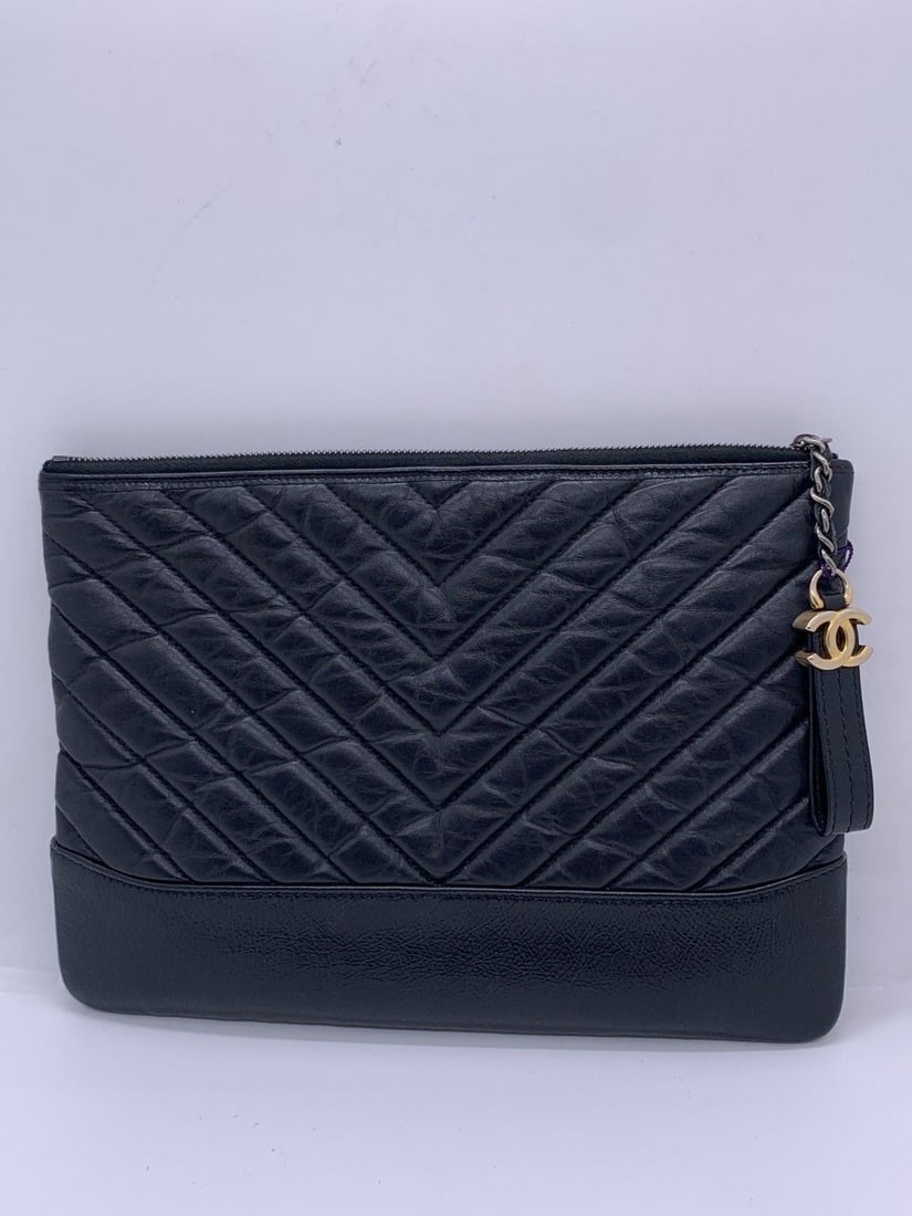 Auth Chanel Gabrielle clutch black aged calfskin chevron quilting Origin Italy: Normal signs of use, worn corners, scratches and slight discoloration on metal fittings, clean interior.