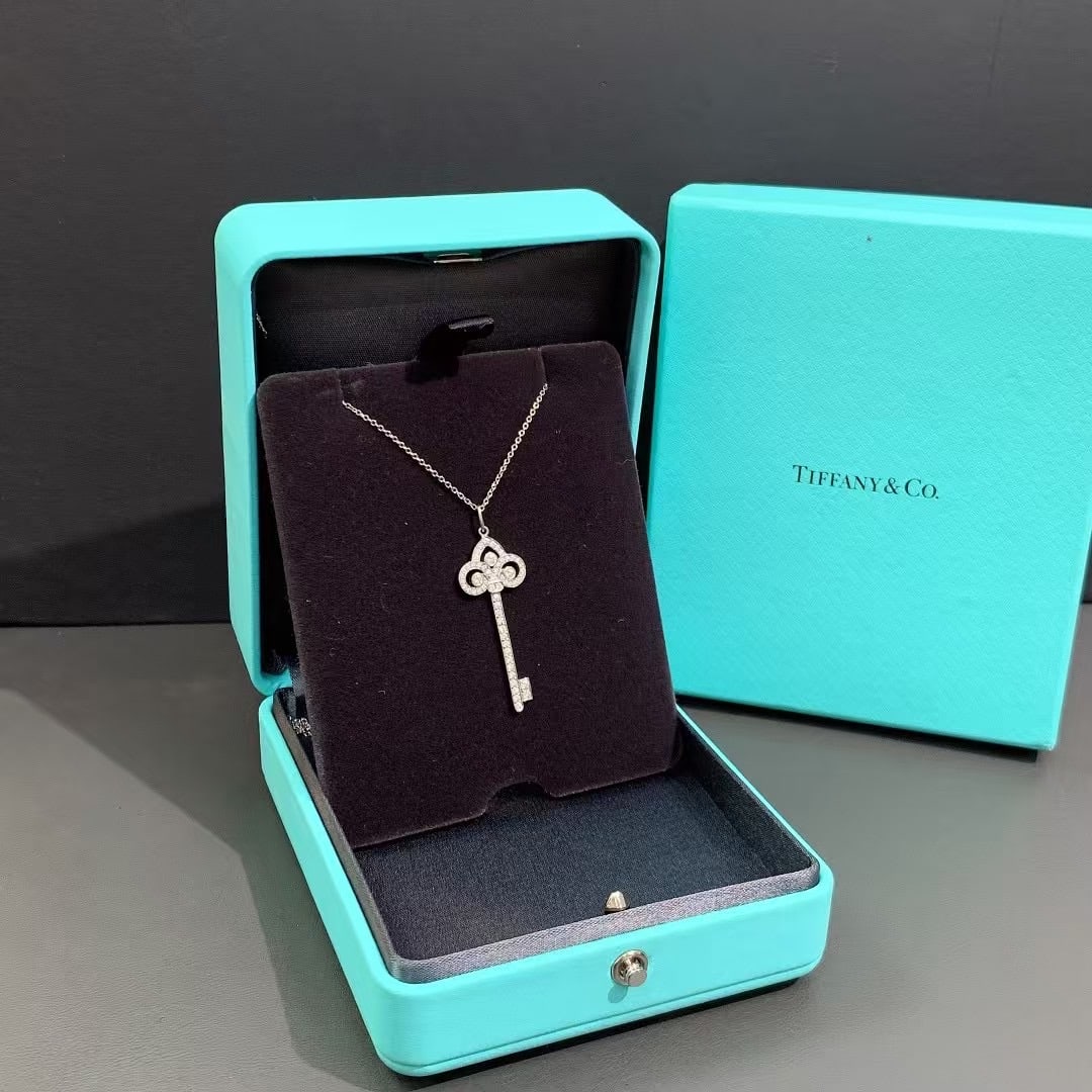 Tiffany Round Brilliant Diamonds Platinum Keys Fleur de Lis Key Pendant: Tiffany Keys Fleur de Lis Key Pendant. It is a signature piece from Tiffany & Co., crafted in platinum and set with round brilliant diamonds.Key DetailsDesign Style: The "Fleur de Lis" motif is featur
