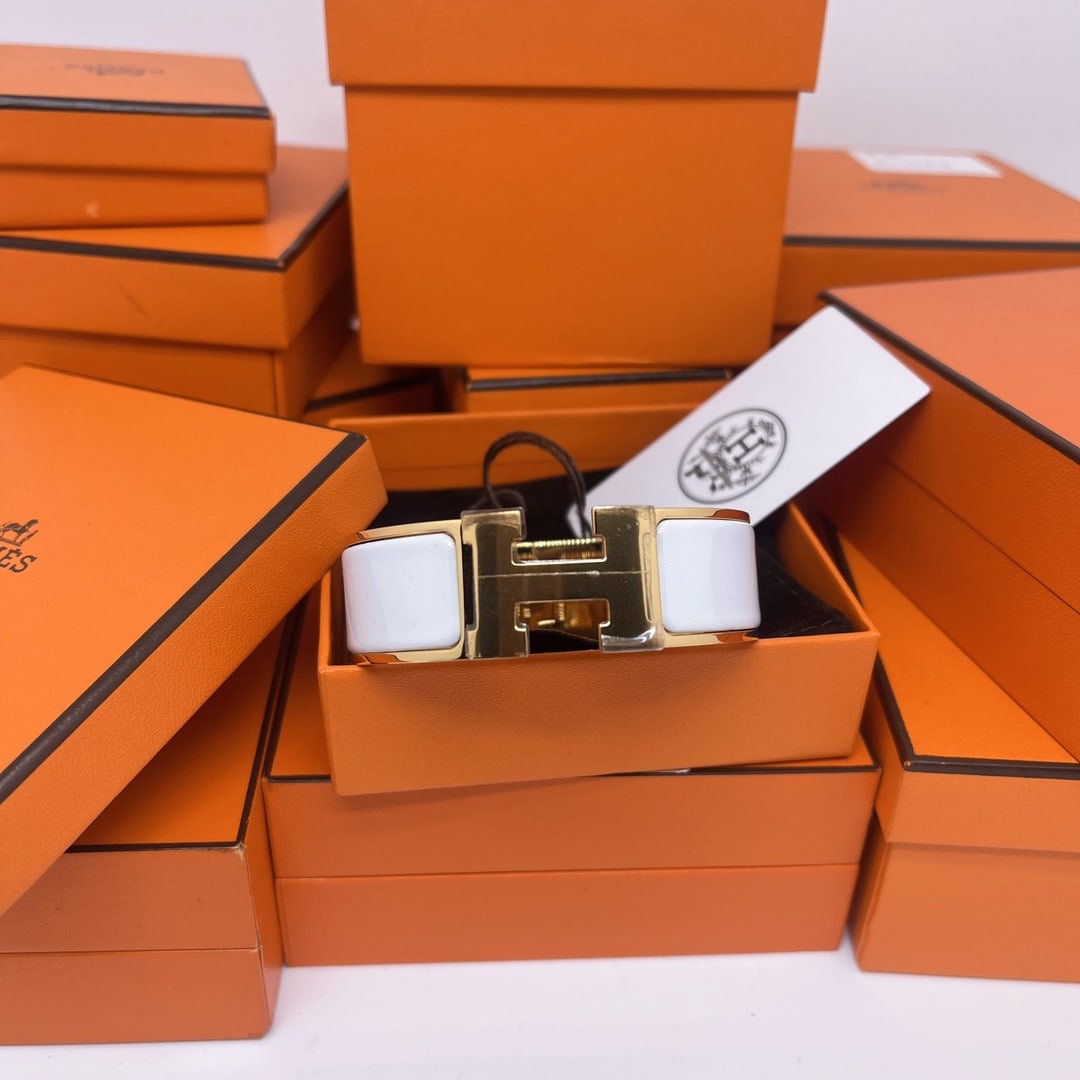 Hermes Clic H bracelet Wide Band Size S: Hermes Clic H bracelet, a signature piece of enamel jewelry from the French luxury house. This specific model features a white (Blanc) enamel band paired with yellow gold-plated hardware.Key FeaturesM