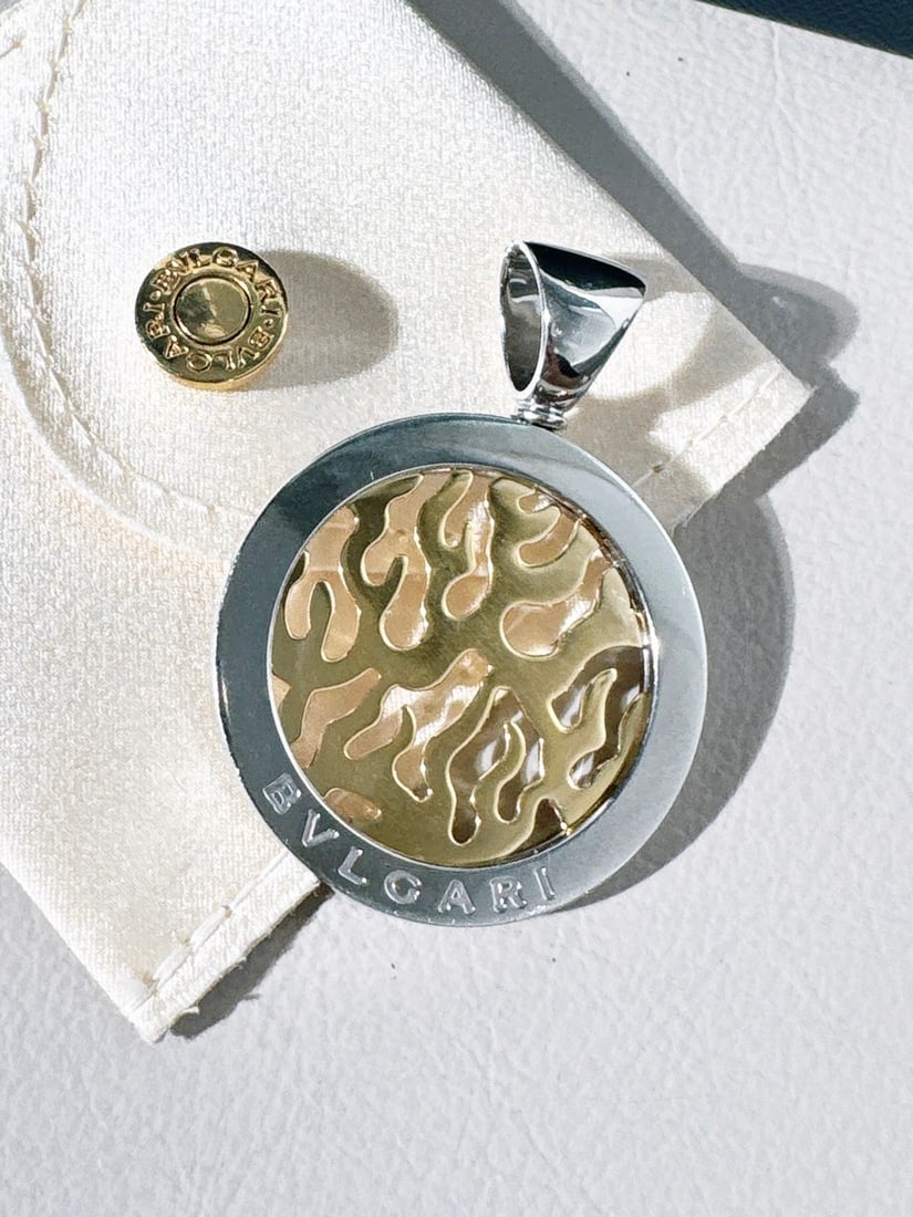 Bvlgari Tondo Fire Pendant 18K Yellow Gold STEEL: Bvlgari Tondo Fire Pendant, a piece from the brand's Tondo collection known for its circular "tondo" shape and contrasting metal finishes.Design and MaterialThe pendant features a "fire" motif in the 