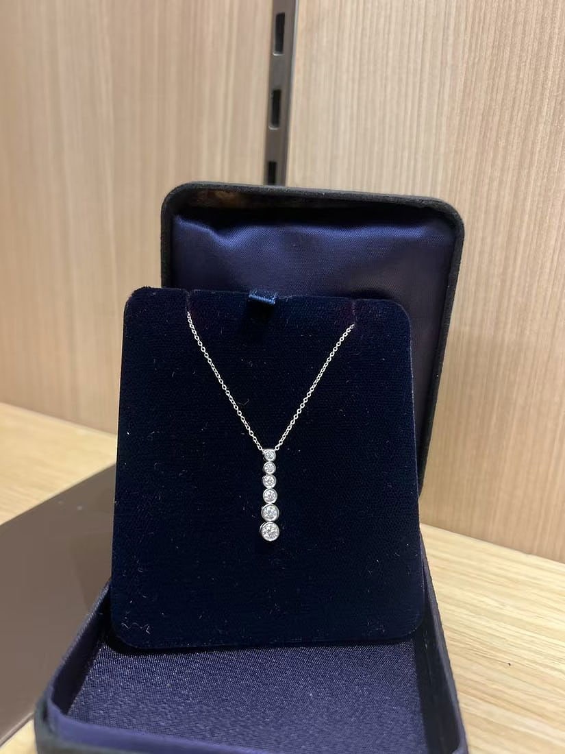 Tiffany Jazz Graduated Drop Platinum Diamond Pendant: Tiffany Jazz Graduated Drop Pendant from the iconic jeweler Tiffany & Co.. This elegant piece is part of the Tiffany Jazz collection, which is characterized by its clean lines and a rhythmic arrangeme
