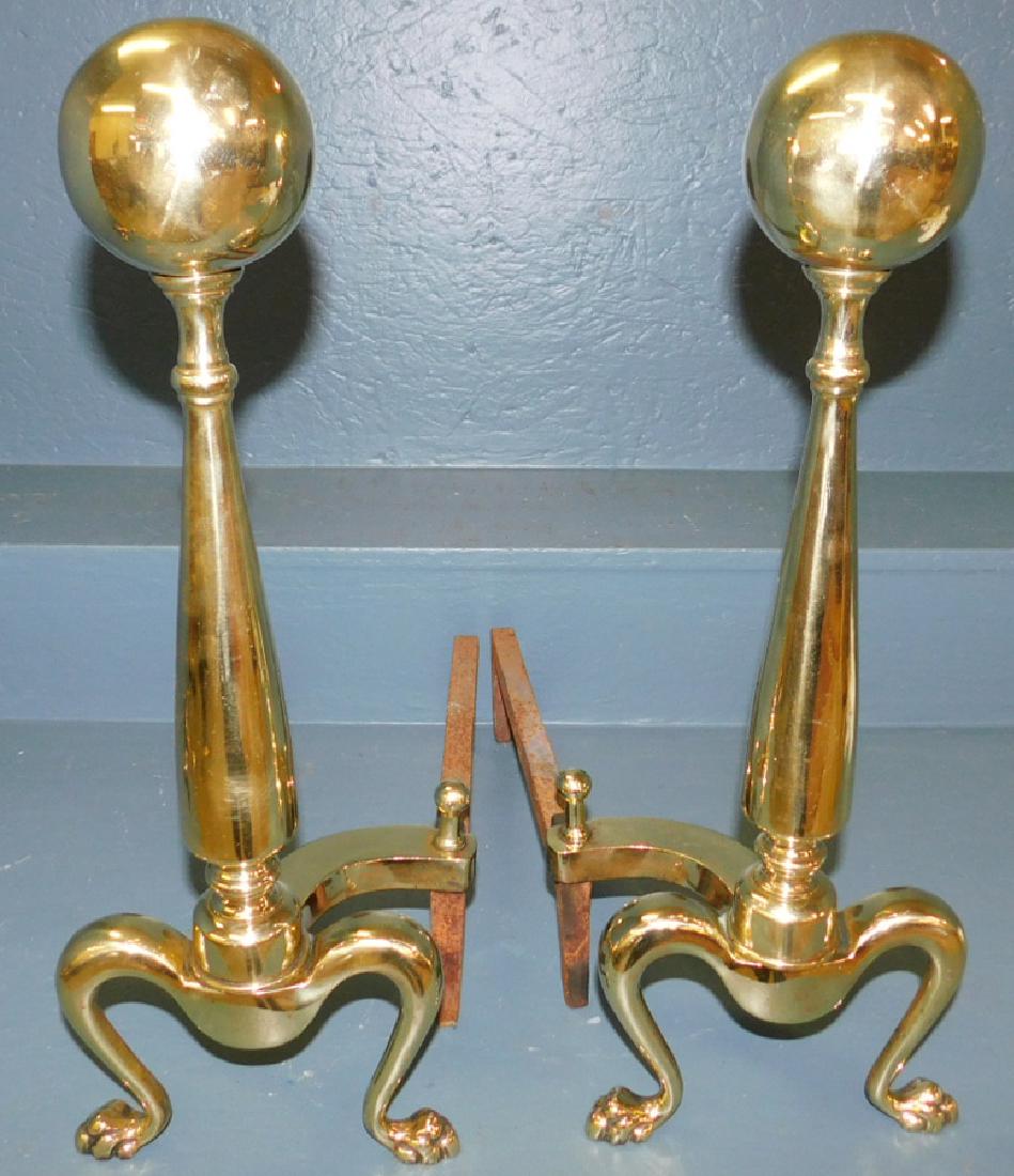 Pair of polished brass cannonball andirons.: Pair of polished brass cannonball andirons. 20" tall.