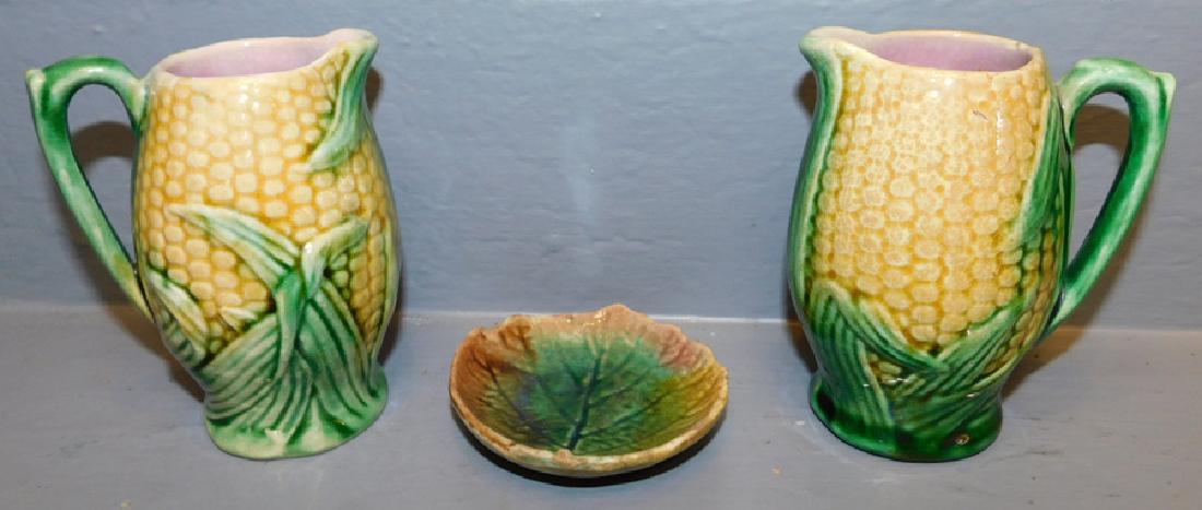 Pair of Majolica corn pitchers and butter pat. (1 of 2)