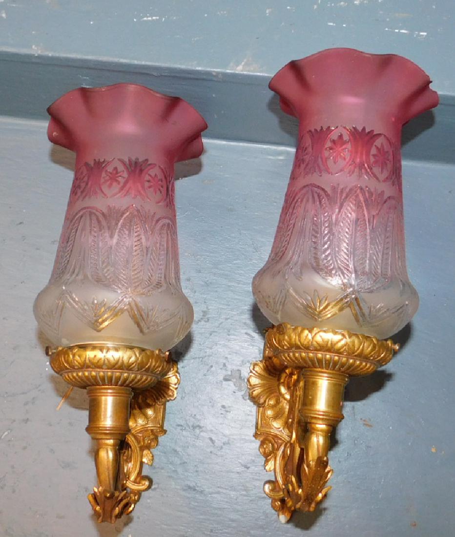 Pair of brass wall sconces with cranberry shades. (1 of 3)