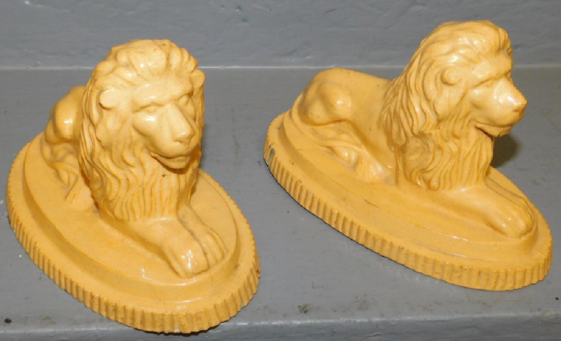 19th c pr. of yelloware recumbent lions: 19th C pair of yelloware recumbent lions. 6 1/2" long.