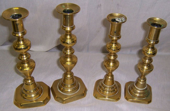 (4) early brass beehive push up candlesticks.: (4) early brass beehive push up candlesticks. 9" and 9 3/4" tall.