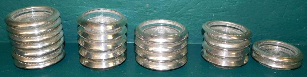 Lot of 22 Sterling Rimmed Coasters: Lot of 22 Sterling Rimmed Coasters. Up to 4 1/4" Dia. ALL DESCRIPTIONS AND ANY CONDITION STATEMENT GIVEN BY LANGSTON AUCTION GALLERY ARE STRICTLY AN OPINION AND LANGSTON'S SHALL HAVE NO RESPONSIBILITY