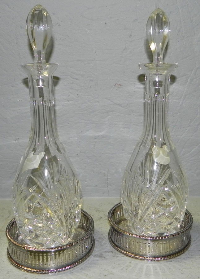 Pr glass decanters & silver plate wine coasters: Pair of glass decanters and silver plate wine coasters. From the Edna Boykin collection.