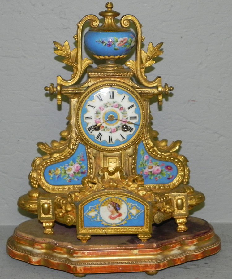 French Dore' bronze mounted clock: French Dore' bronze mounted clock with Sevres type porcelain panels. 12" wide x 14 1/2" tall.