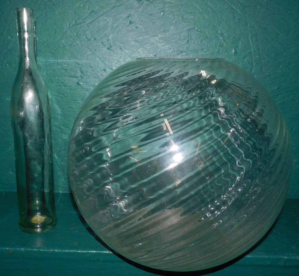 Glass Fish Bowl & Wine Bottle: Glass Fish Bowl & Wine Bottle. 15 1/4" H ALL DESCRIPTIONS AND ANY CONDITION STATEMENT GIVEN BY LANGSTON AUCTION GALLERY ARE STRICTLY OPINIONS AND LANGSTON'S SHALL HAVE NO RESPONSIBILITY FOR ERRORS OR 