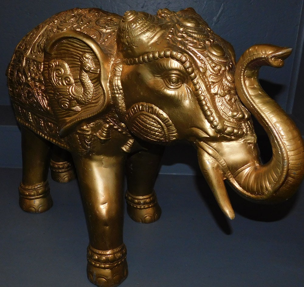 Gilt Cast Aluminum Elephant Statue (Missing One Tusk): Gilt Cast Aluminum Elephant Statue (Missing One Tusk). 30" W 20 1/2" H ALL DESCRIPTIONS AND ANY CONDITION STATEMENT GIVEN BY LANGSTON AUCTION GALLERY ARE STRICTLY OPINIONS AND LANGSTON'S SHALL HAVE NO