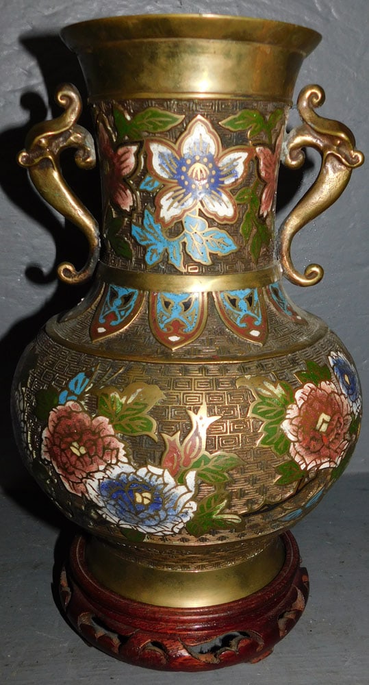 Champleve Urn On Teak Wood Stand: Champleve Urn On Teak Wood Stand. 12" H ALL DESCRIPTIONS AND ANY CONDITION STATEMENT GIVEN BY LANGSTON AUCTION GALLERY ARE STRICTLY OPINIONS AND LANGSTON'S SHALL HAVE NO RESPONSIBILITY FOR ERRORS OR O