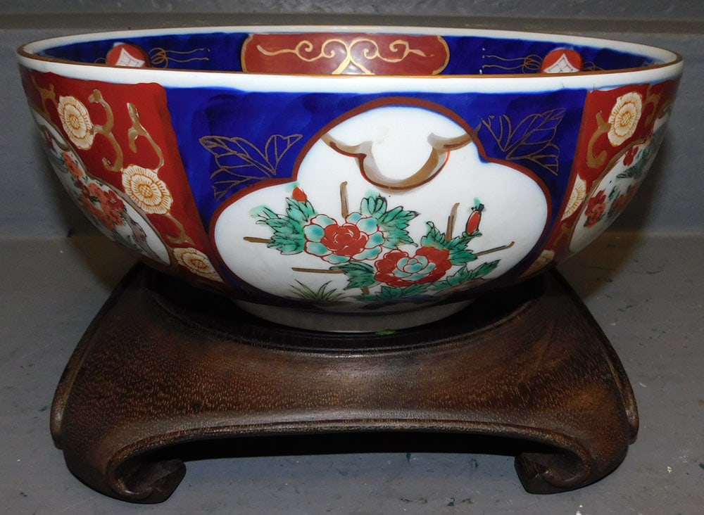 Gold Imari Bowl On Teak Wood Stand: Gold Imari Bowl On Teak Wood Stand. 11" Dia 6 1/2" H "ALL DESCRIPTIONS AND ANY CONDITION STATEMENT GIVEN BY LANGSTON AUCTION GALLERY ARE STRICTLY OPINIONS AND LANGSTON'S SHALL HAVE NO RESPONSIBILITY F