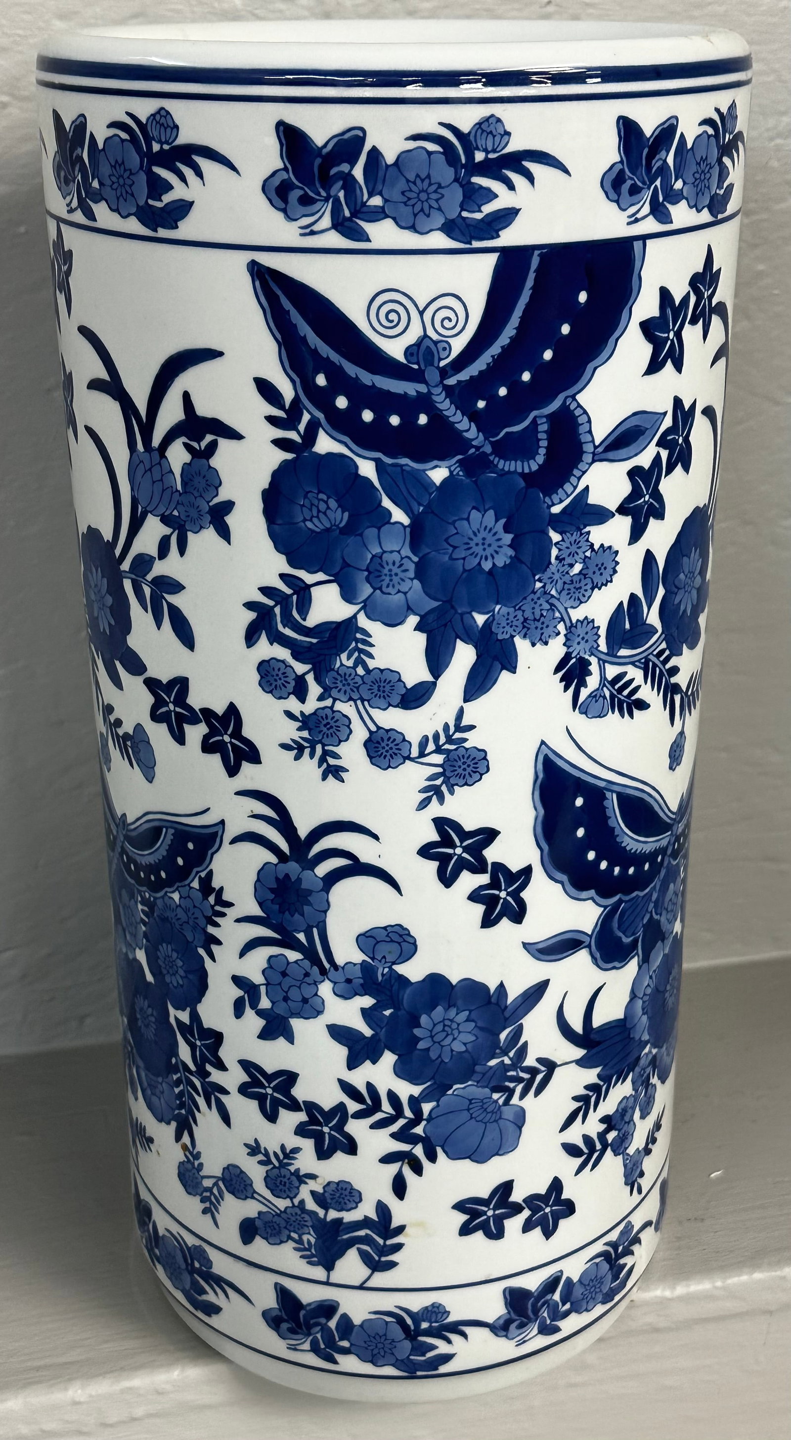 Oriental Blue & White Decorated Porcelain Umbrella Stand with Butterfly Motif: Oriental Blue & White Decorated Porcelain Umbrella Stand with Butterfly Motif. 18” H 9” Dia. "ALL DESCRIPTIONS AND ANY CONDITION STATEMENT GIVEN BY LANGSTON AUCTION GALLERY ARE STRICTLY OP