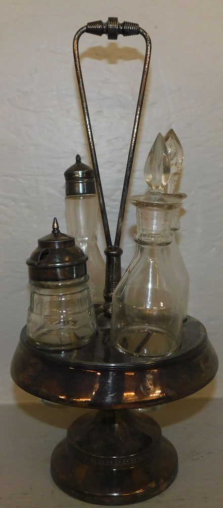 silver plated in glass cruet stand: silver plated in glass cruet stand. 14 1/2" H ALL DESCRIPTIONS AND ANY CONDITION STATEMENT GIVEN BY LANGSTON AUCTION GALLERY ARE STRICTLY OPINIONS AND LANGSTON'S SHALL HAVE NO RESPONSIBILITY FOR ERROR
